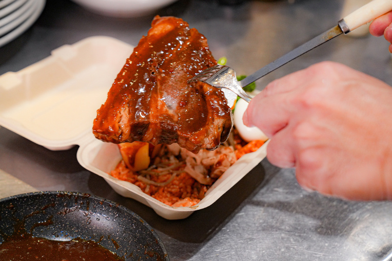 バガス容器にお弁当を盛り付ける様子