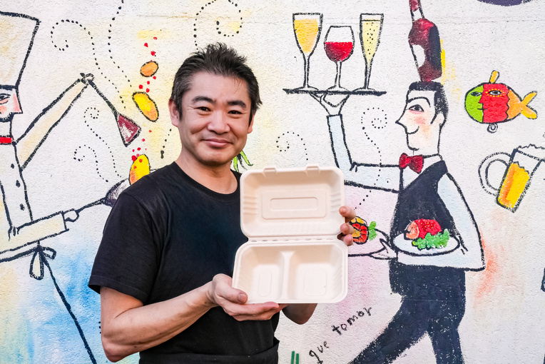 バガス容器を持った伊藤氏