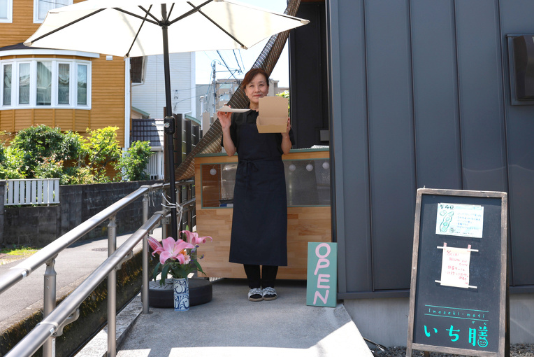 バガス容器を持ついち膳オーナーと店舗外観